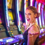 Young happy woman at a casino playing with slot machines